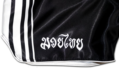 black boxing shorts with white stripes and the inscription muay thai in Thai script