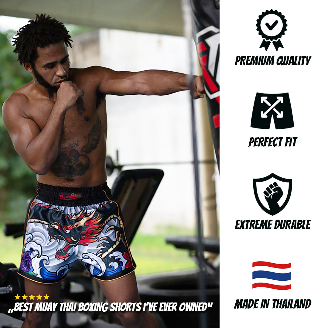 Male Muay Thai fighter training with a punching bag, wearing Irezumi Dragon Muay Thai Shorts featuring a vibrant dragon and wave design. The shorts, handmade with premium materials, showcase Japanese-inspired art, enhancing both style and functionality for intense workouts.