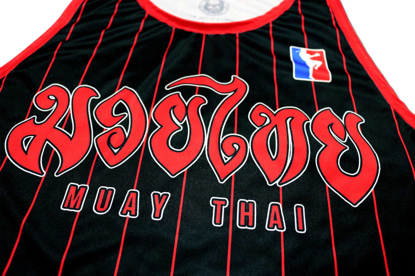 closeup from a black muay thai tank top with a big red muay thai logo on the chest