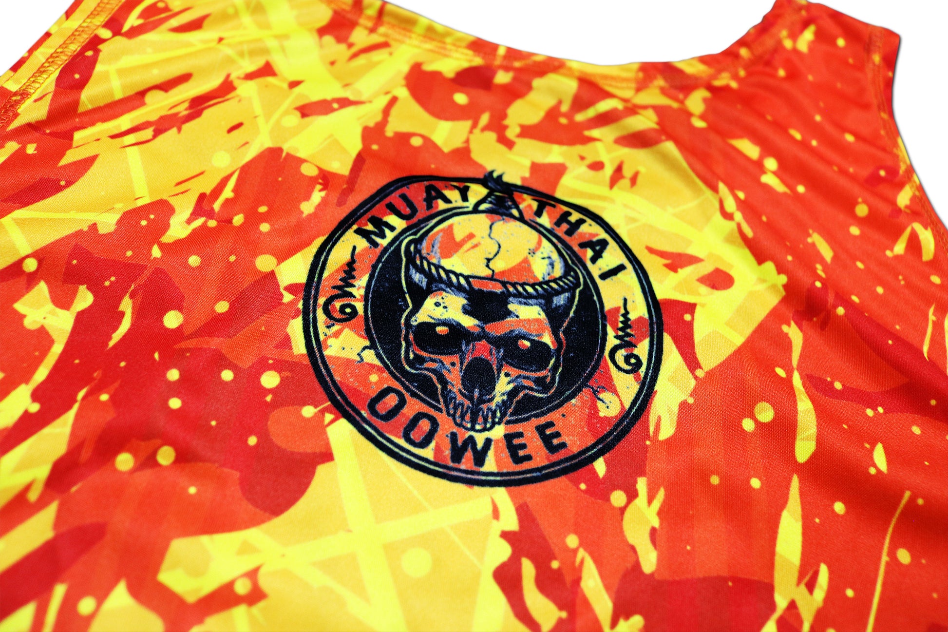 Close-up view of the back of the brand new LAVA Muay Thai tank top, showcasing the fiery red and yellow design with a circular black OOWEE Muay Thai logo